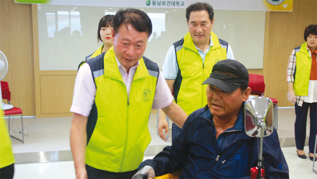 홍 총장이 한국지체장애인협회 수원시지회 소속 회원들의 전동 휠체어를 살펴보고 있다.