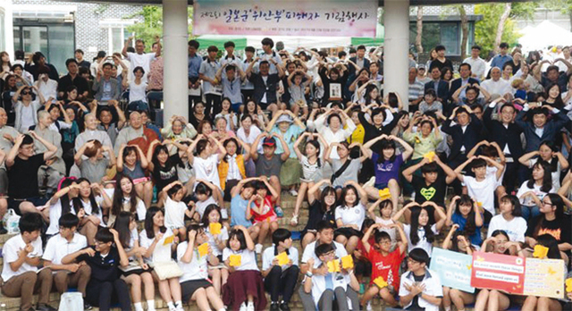‘제2회 일본군 위안부 피해자 기림행사’가 열린 8월12일 오전 광주시 나눔의 집에서 참석 내빈들과 자원봉사자들이 이옥선, 박옥선, 이용수, 박필근, 정복수 할머니와 함께 머리 위로 하트를 만들고 기념촬영을 하고 있다.