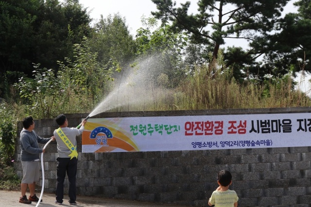 ▲ 마을자체 소화전에 연결한 호스로 소화시범을 보이는 주민들.