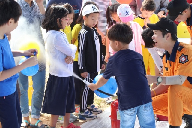▲ 소화기 작동법을 배우고있는 숲속마을 어린이들