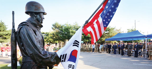 ▲ 미 제2보병사단한미연합사단 창설 100주년 기념 동상 제막식이 열린 16일 의정부시 캠프 레드클라우드 프리맨 홀에서 새롭게 제작된 지평리 전사상이 한미 연합을 알리는 태극기, 성조기와 함께 모습을 드러내고 있다.  조태형기자