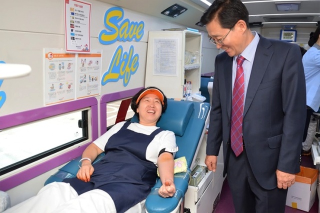 ▲ 백혈병 아동을 돕기 위해 헌혈을 하는 직원을 격려하고 있는  황순창양평공사 사장