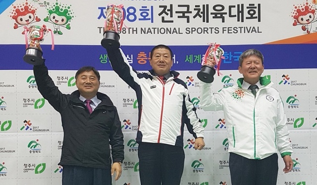▲ 제98회 전국체육대회 유도에서 19연패를 달성한 경기도선수단 서정복 총감독(가운데)이 우승 트로피를 들고 있다.