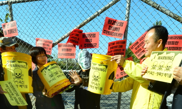 ▲ 30일 오전 인천시 부평구 미군기지 '캠프마켓' 정문 앞에서 지역 정치권과 시민·환경단체 등 62곳이 참여한 '인천 제정당·시민사회단체' 회원들이 주한미군의 사과와 자체 오염 정화를 촉구하는 퍼포먼스를 하고 있다.장용준기자