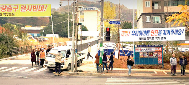 ▲ 인천시 서구 가정초교 옆 신축 아파트의 주차장 비상출구가 학생 통학로와 겹치게 설치되면서 공사현장 앞에 학생들의 사고위험을 우려하는 학부모들의 현수막이 내걸려 있다. 독자제공