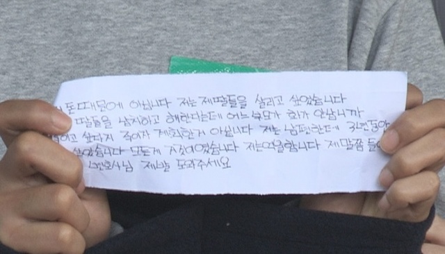 ▲ 10일 오전 용인 일가족 살해사건 피의자의 아내가 검찰에 송치되면서 용인동부경찰서 앞에서 '억울하다'는 내용이 적힌 쪽지를 펴 들어보이고 있다. ▲사진=연합뉴스 (2)