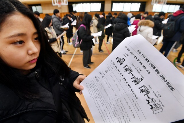 ▲ 포항 지진 발생으로 일주일 연기된 2018학년도 대학수학능력시험 예비소집일인 22일 수원 북중학교 체육관에서 수험생들이 교육청에서 배부한 수능 지진 대처 단계별 행동 요령을 꼼꼼히 읽고 있다. 김시범기자