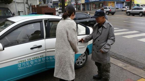 ▲ 김씨가 경기도의료원 수원병원 관계의 도움을 받아 집으로 가는 차를 타고 있다
