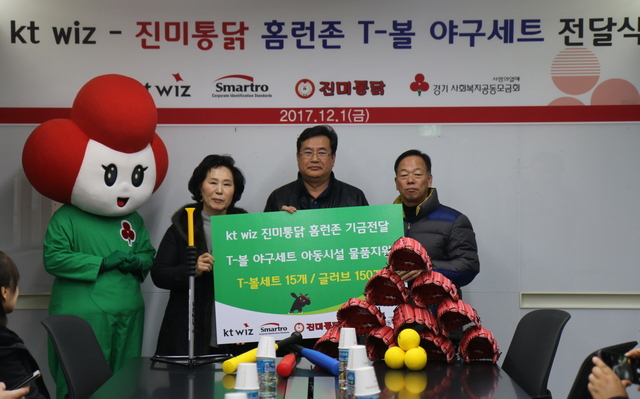 kt wiz가 1일 수원 케이티 위즈파크에서 진행한 ‘진미통닭 홈런존 T볼 야구세트 전달식’에서 kt wiz 임종택 단장(가운데)과 진미통닭 박순종 대표이사(오른쪽),수원지역아동센터 연합회 김복희 회장(왼쪽)이 기념 촬영을 하고 있다.kt wiz 제공