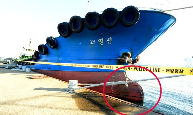 ▲ 4일 오후 인천시 중구 인천해경 전용부두에서 해양경찰을 비롯한 유관기관 감식반원들이 침몰했던 낚싯배 선창1호의 밑바닥 부분을 감식하고 있다(왼쪽). 그시각 인천시 중구 북항 관공선부두에  선창1호와 충돌한 급유선 명진15호가 정박해 있다. 한편, 명진15호 선수 아래(빨간 동그라미)에는 선창1호 밑바닥 색상인 것으로 추정되는 파란색이 묻어 있다.장용준기자