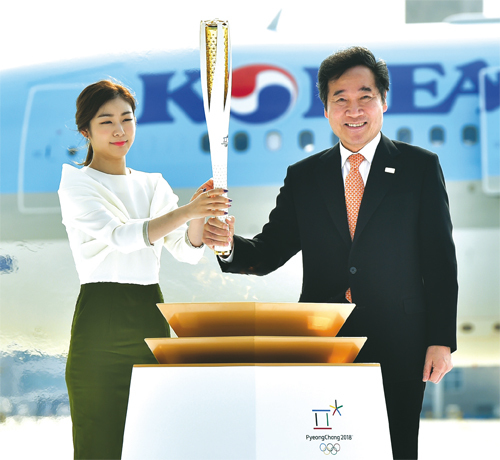 지난 11월 1일 인천공항 제2여객터미널에서 열린 ‘2018 평창동계올림픽 성화 환영행사’에서 이낙연 국무총리와 김연아 홍보대사가 그리스에서 채화한 성화 불씨를 들고 입장하고 있다.