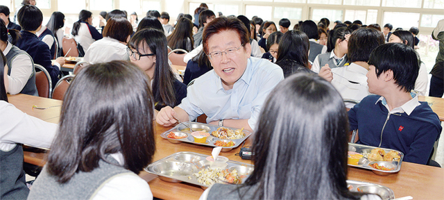학생들의 건강한 성장을 위해 친환경무상급식을 지원하는 성남시의 이재명 시장이 관내 학교에서 학생들과 급식을 먹고 있다.