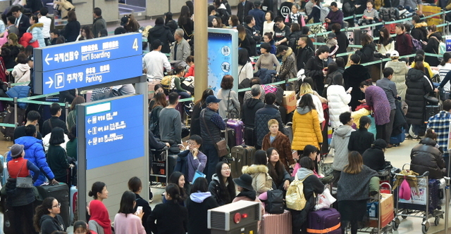 ▲ 전날부터 안개와 항공기 순차적 이착륙으로 항공편 지연이 계속된 24일 오전 인천국제공항 출국장에 여행객들이 줄지어 수속 차례를 기다리고 있다.장용준기자