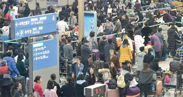▲ 안개로 인해 이틀째 항공편이 무더기로 지연된 24일 오전 인천국제공항 출국장 일대가 발이 묶이거나 출국 수속을 하려는 여행객들이 뒤엉켜 북새통을 이루고 있다. 장용준기자