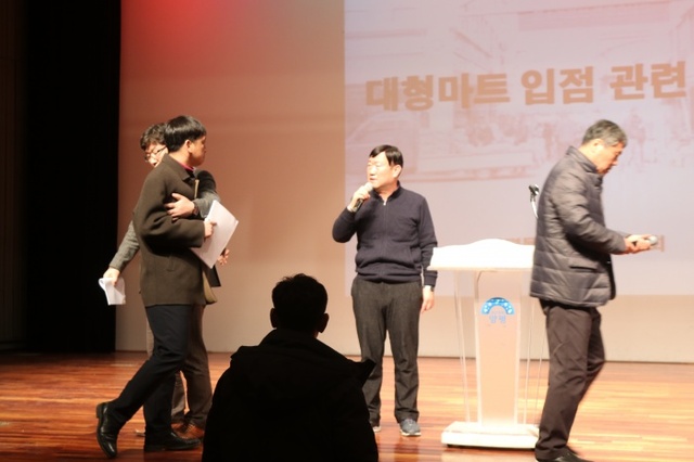 ▲ 지난5일 시장상인회가 개최한 롯데마트입점관련  군민설명회에서 상인회 고건덕회장이 설명하는 도중 비대위측 상인이 항의하는 소동이  일어났다.