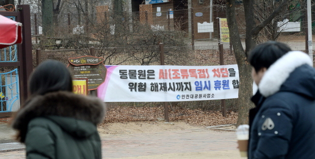 7일 오전 휴일을 맞아 인천대공원을 찾은 시민들이 고병원성 조류인플루엔자(AI) 유입을 막기 위해 어린이동물원 입구 앞에 게시된 퍠쇄 안내문을 바라보고 있다. 인천시는 고병원성 AI가 수도권에서도 퍼질 조짐을 보이자, 지난 6일부터 동물원과 주변 등산로를 무기한 폐쇄했다.장용준기자 