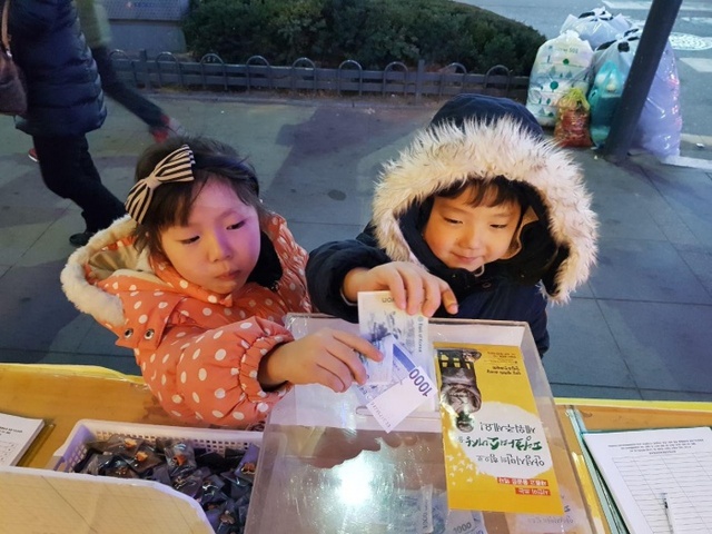 ▲ 소녀상 건립을 위한 거리모금에서 쌍둥이 자매가 모금함에 기부를 하고 있다. 평화의 소녀상 건립 추진위 제공