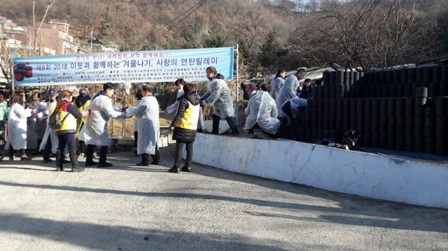▲ 지난 6일 (사)월드유스비전 경기도지부와 자원봉사자 450명이 함께 광명7동 무허가촌에서 사랑의 연탄릴레이행사를 진행하고 있다. 광명시 제공