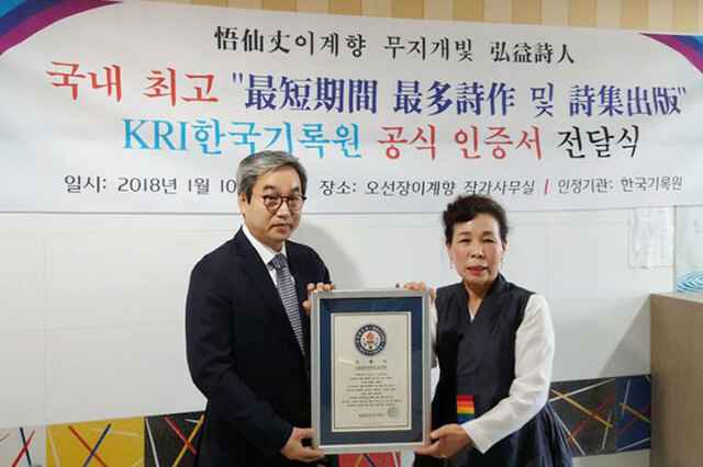▲ 지난 10일 홍익작가 사무실에서 한국기록원 원장이 이계향 시인에게 인증서를 수여하고 있다