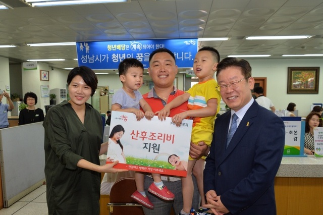 ▲ 이재명 성남시장이 산후조리지원비를 받은 가족과 함께 기념사진을 찍고 있다.