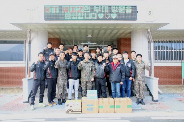 ▲ 17일 오후 연천군에 위치한 육군 제5보병사단 공병대대 대대본부 앞에서 김용국 수석코치 등 kt wiz 선수단이 후원물품을 전달한 뒤, 기념촬영에 임하고 있다.kt wiz 제공
