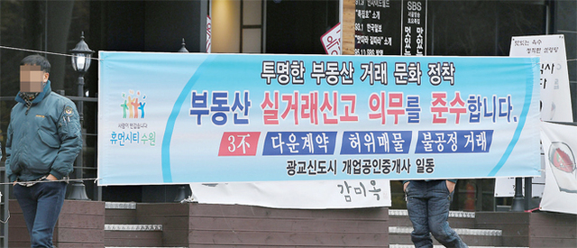 ▲ 18일 수원시 영통구의 한 사거리에 다운계약, 허위매물, 불공정 거래를 하지 않는 청렴한 부동산 문화 정착을 장려하는 광교신도시 개업공인중개사회의 현수막이 설치되어 있다. 조태형기자