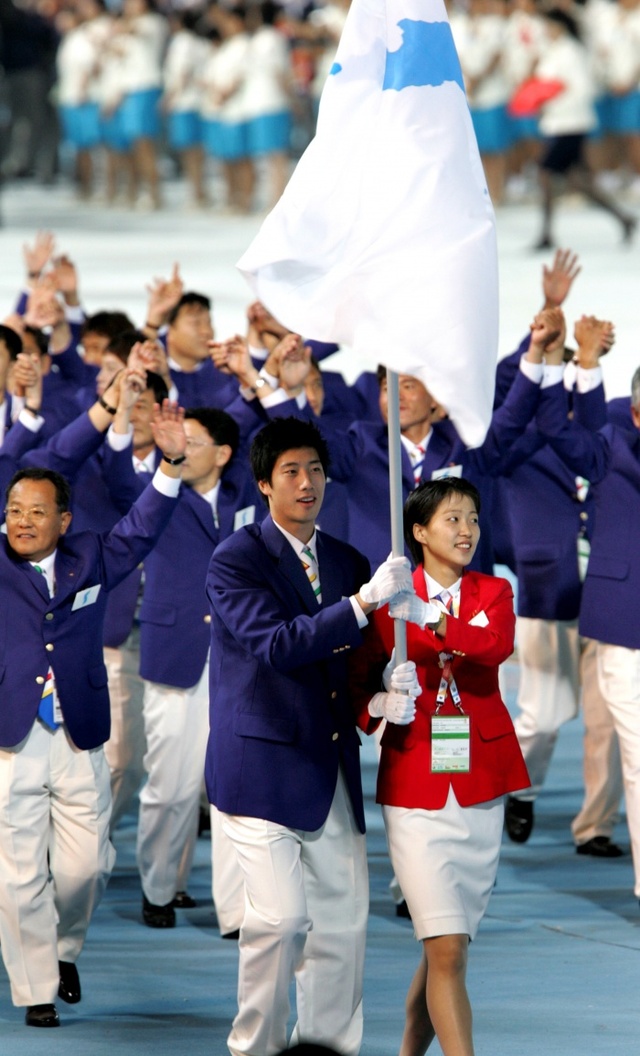 ▲ 2005년 제4회 마카오 동아시아경기대회에서 남북 공동기수를 맡은 남측의 남자 기수 양현종과 북측의 여자 기수 유현순이 한반도기를 들고 입장하고 있다.경기일보 DB