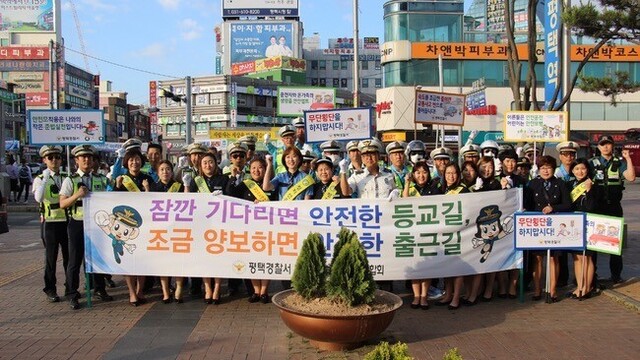 평택경찰서가 녹색어머니연합회 등 유관 기관 회원들과 함께 등굣길 교통안전 캠페인을 펼치고 있다. 평택경찰서 제공