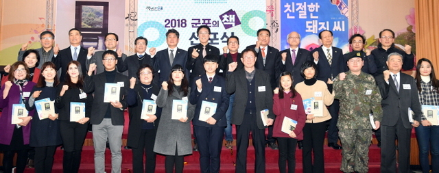 ▲ 31일 군포시청 대회의실에서 열린 ‘2018 군포의 책 선포식’에서 김윤주 군포시장, 이석진 군포시의회 의장,  장석주, 신경민 작가 등 참석자들이 독서릴레이 첫 주자인 시민들에게 군포의 책으로 선정된 도서전달 후 기념촬영을 하고 있다.전형민기자