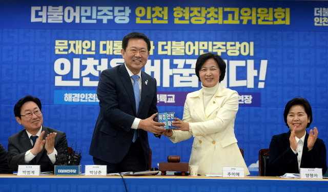 ▲ 5일 오전 '더불어민주당 인천 현장최고위원회'가 열린 인천시 남동구 더불어민주당 인천시당에서  추미애 더불어민주당 대표가 박남춘 더불어민주당 인천시당 위원장에게 '해경 인천환원'을 축하하는 홍보물을 건네고 있다.장용준기자