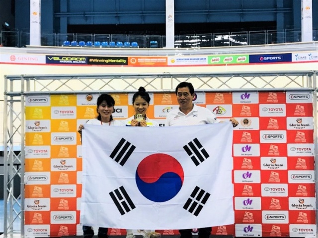 ▲ 2018 아시아트랙사이클선수권대회 여자 3km 개인추발서 금메달을 획득한 이주미(가운데)가 최병창 감독(오른쪽) 등과 함께 기념촬영을 하고 있다.대한자전거연맹 제공