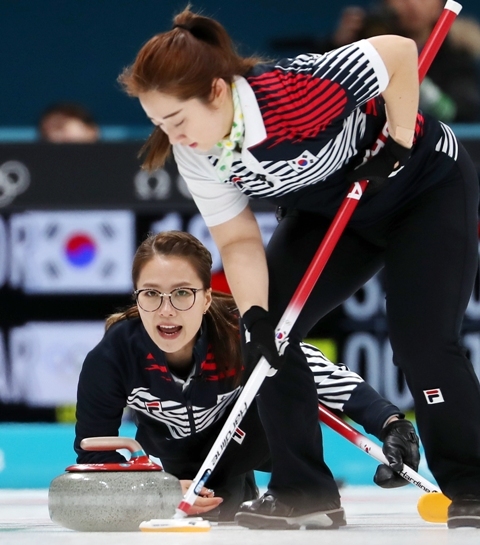 ▲ 21일 강릉컬링센터에서 열린 여자 컬링 예선 대한민국과 러시아 출신 올림픽 선수(OAR)의 경기에서 대한민국 스킵 김은정(왼쪽)이 스톤을 딜리버리 하며 김영미에게 스위핑을 요청하고 있다. /연합