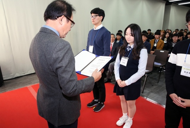 ▲ 천만장학회 윤은기 이사장(왼쪽)이 장학생들에게 장학증서를 수여하고 있다