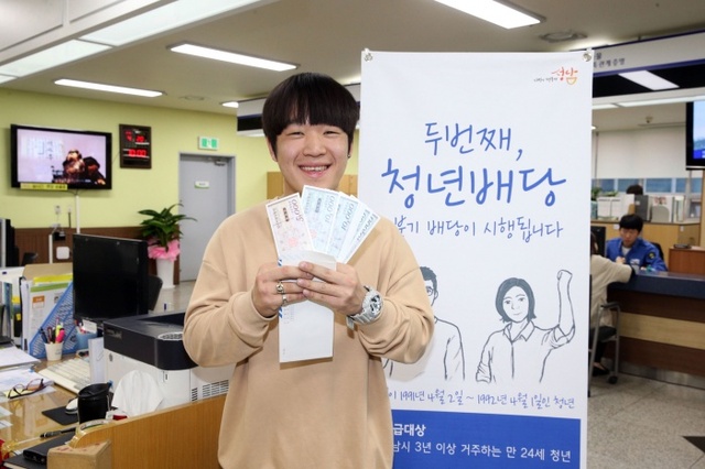 ▲ 성남사랑상품권으로 청년배당 받은 청년이 활짝 웃고 있다. 사진=성남시 제공