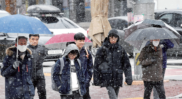 ▲ 낮과 밤의 길이가 똑같은 춘분인 21일 수도권 지역에 눈이 내린 가운데 수원시 장안구 송죽동 한 거리에서 시민들이 눈을 맞으며 걷고 있다. 김시범기자