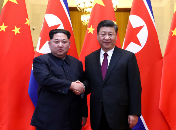 ▲ 미국 언론들은 27일(현지시간) 북한 김정은의 중국 방문엔 도널드 트럼프 대통령과의 북미정상회담을 앞둔 북측의 여러 가지 노림수가 깔렸다는 분석을 내놨다. 북한의 가장 중요한 동맹이면서도 2011년 김 위원장 집권 이후 긴장이 고조돼온 중국과의 관계를 복원, 이를 지렛대로 대미 협상력을 높임으로써 판세를 유리한 국면으로 가져가는 동시에 제재완화 등을 얻어내고 협상 실패 시 미국이 꺼내 들 수 있는 군사옵션을 막는 등의 포석이 담겨 있다는 것이다. 사진은 김정은(왼쪽)이 이날 베이징의 인민대회당에서 중국 시진핑 국가주석과 만나 악수하는 모습. 연합뉴스