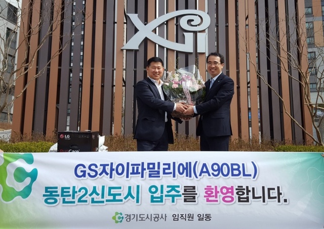 ▲ 강입주선물 전달식(사진 왼쪽 입주민 강용중씨 오늘쪽 박순호 동탄고덕사업단장)