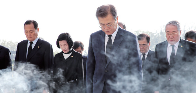 문재인 대통령이 19일 오전 서울 국립 4.19민주묘지를 방문, 4.19 기념탑에 헌화 분향한 뒤 묵념하고 있다. 연합뉴스