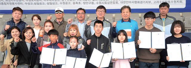 ‘제16회 경기마라톤대회’가 열린 22일 수원종합운동장에서 장학금을 전달받은 육상 꿈나무들과 지도자들이 신항철 경기일보 대표이사 사장, 조덕원 경기도육상연맹 회장과 기념촬영을 하고 있다.