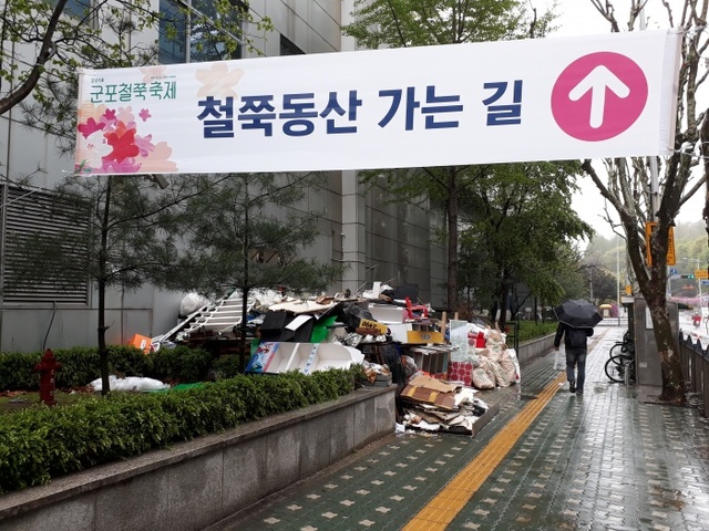 ▲ 군포시 산본역 1층 창고앞에 각종 쓰레기가 화단과 인도를 점령하며 한달여째 방치되고 있다.