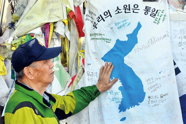 ▲ 남북정상회담을 이틀 앞둔 25일 오후 파주 임진각을 찾은 한 6·25 참전용사가 통일을 기원하며 철조망에 내걸린 한반도기를 어루만지며 생각에 잠겨 있다. 김시범기자