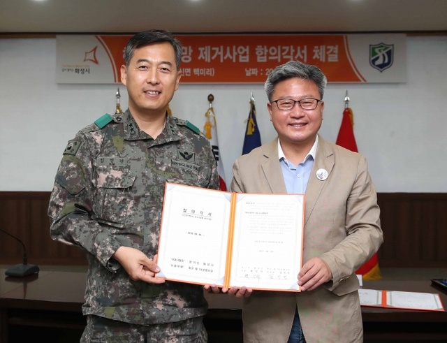 ▲ 채인석 화성시장(왼쪽)과 김인건 육군 51사단장이 26일 합의각서를 체결한 뒤 기념촬영을 하고 있다.화성시 제공