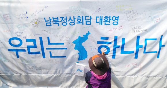 ▲ 27일 오전 경기도 파주 임진각에서 시민들이 자유의 다리에 설치된 대형현수막에 메시지를 작성하고 있다. 판문점공동취재단=연합뉴스