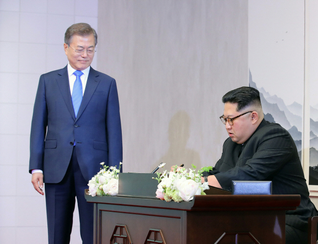 ▲ 방명록 쓰는 김정은 문재인 대통령이 27일 오전 파주시 판문점 평화의 집에서 남북정상회담에 앞서 방명록을 쓰고 있는 북한 김정은 국무위원장을 보고 있다. 판문점 공동취재단=연합뉴스