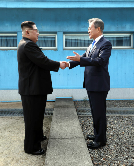 ▲ 문재인 대통령과 북한 김정은 국무위원장이 27일 판문점 군사분계선을 사이에 두고 악수하고 있다. 판문점공동취재단=연합뉴스