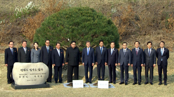 ▲ 문재인 대통령과 김정은 북한 국무위원장이 27일 오후 판문점 군사분계선 인근 ''소떼 길''에서 평화와 번영을 기원하는 소나무 공동식수를 마친 뒤 주요 참석자들과 기념촬영을 하고 있다. 판문점공동취재단=연합뉴스