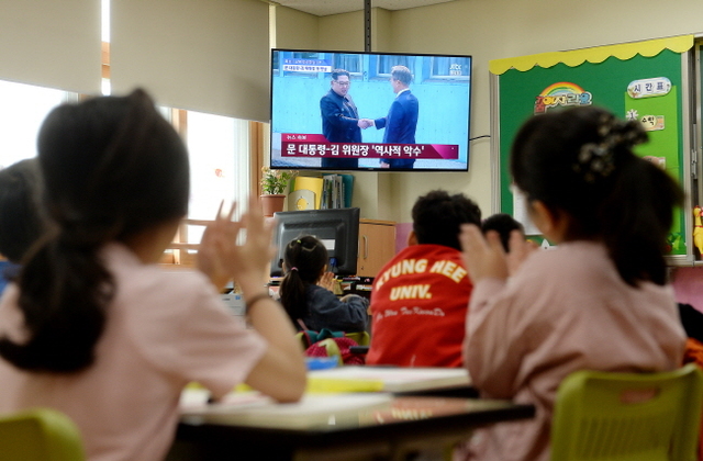 ▲ 역사적인 남북정상회담이 열린 27일 오전 인천시 서구 가원초교 1학년 학생들이 박수를 치며 생중계 뉴스를 시청하고 있다.장용준기자