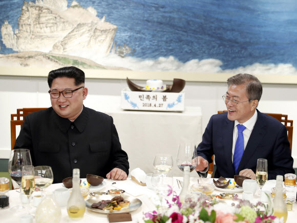 ▲ 문재인 대통령과 김정은 북한 국무위원장이 27일 오후 판문점 평화의집에서 열린 환영만찬에서 함께 나무망치를 들고 디저트인 초콜릿 원형돔 ‘민족의 봄’을 개봉한 뒤 함께 미소짓고 있다. 판문점공동취재단=연합뉴스