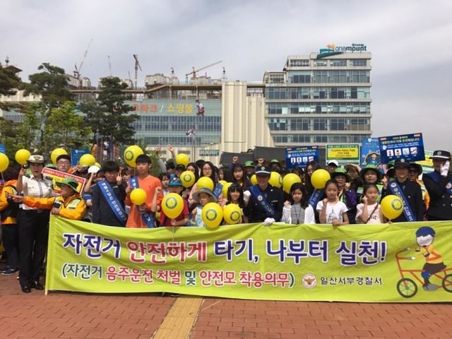 ▲ 일산서부서가 교통사고 예방을 위한 슈즈나이트 배부 및 교통안전 캠페인을 벌이고 기념사진을 찍고 있다.(사진제공=일산서부서)