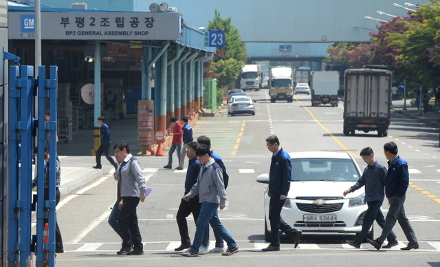 정부와 제너럴모터스(GM)가 한국GM 정상화를 위해 약 7조7천억원의 자금을 투입하며 회생안에 최종 합의한 10일 인천시 부평구 청천동 한국GM 부평공장에서 줄지어 오가는 직원들 너머로 생산부품 트럭들이 분주히 오가고 있다.장용준기자